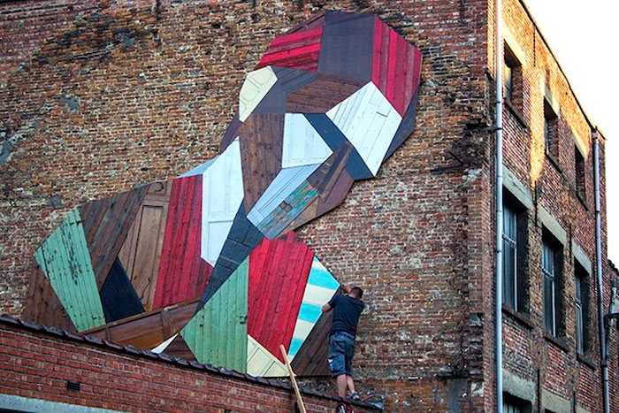 Este artista convierte viejas puertas de madera en enormes murales callejeros