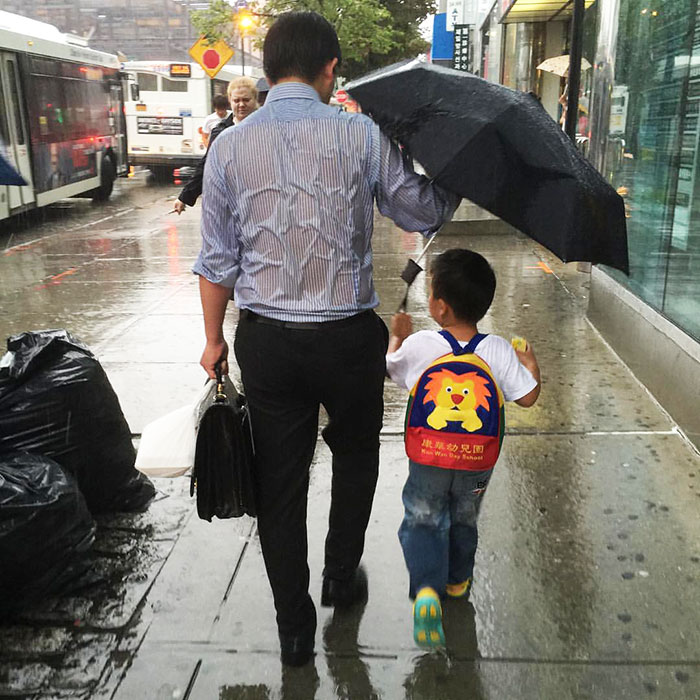 Este padre empapado protegiendo a su hijo de la lluvia muestra lo que es la paternidad