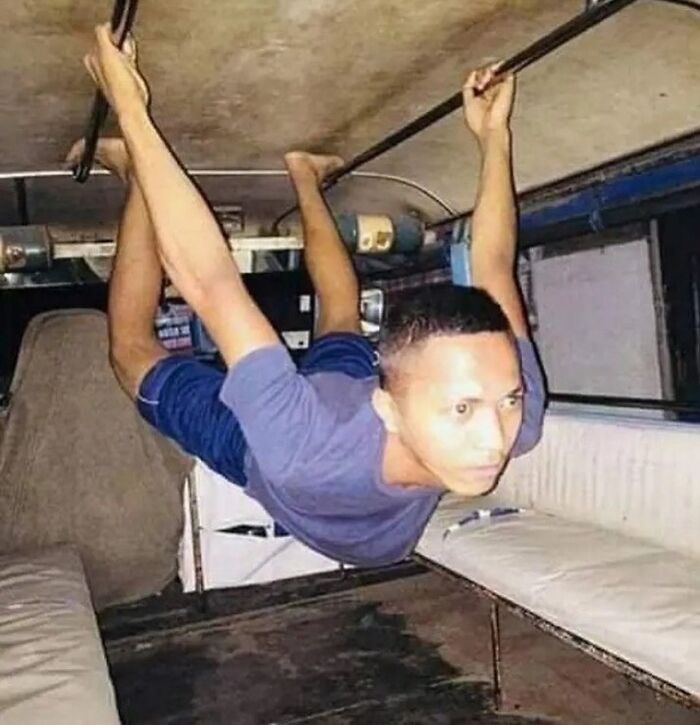 Hombre colgando boca abajo dentro de un vehículo, imagen extraña y misteriosa sin explicación clara.