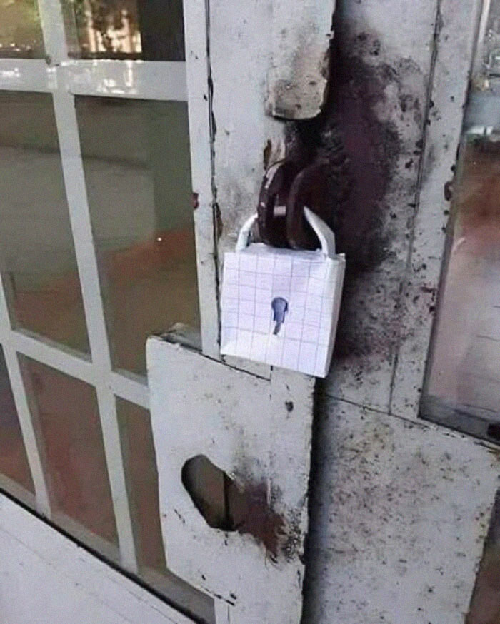 Candado improvisado con papel cuadriculado en puerta vieja, ejemplo de personas que menos mal hicieron una foto.