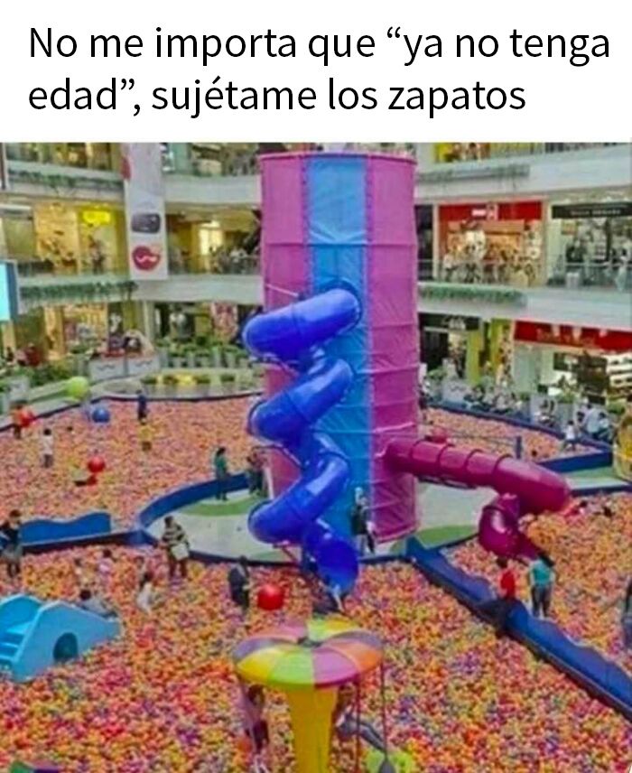 Parque de bolas en centro comercial con toboganes, personas jugando y ambiente divertido para memes entretenidos.
