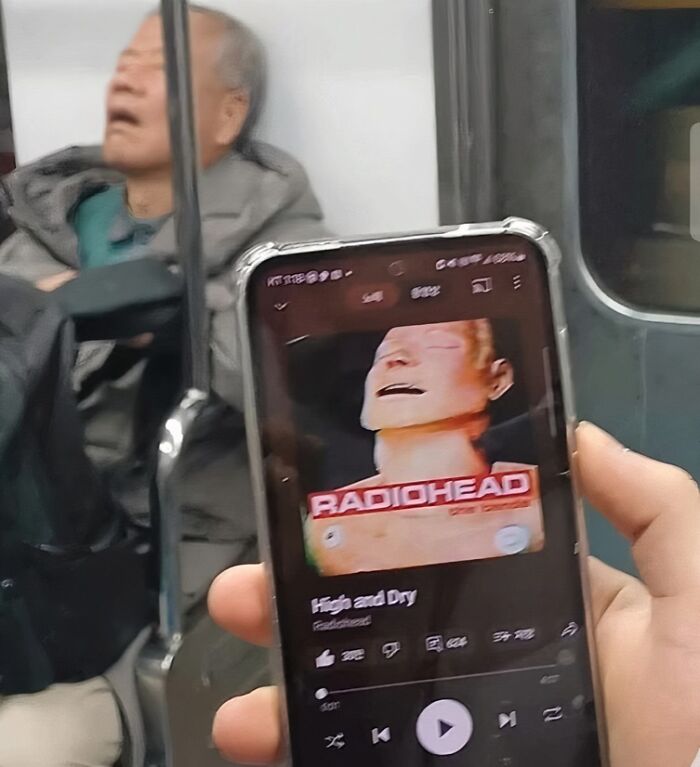 Persona con teléfono mostrando música de Radiohead, imagen divertida de Reino Unido que refleja el humor británico.