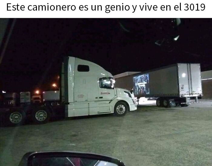 Camionero futurista con camión blanco conectado de forma inusual a remolque en estacionamiento nocturno, captura inusual de pantalla.