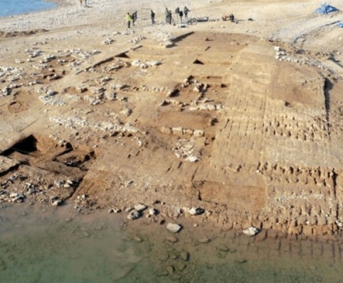 Sitio arqueológico antiguo parcialmente sumergido en agua, con estructuras y restos visibles para datos históricos interesantes.