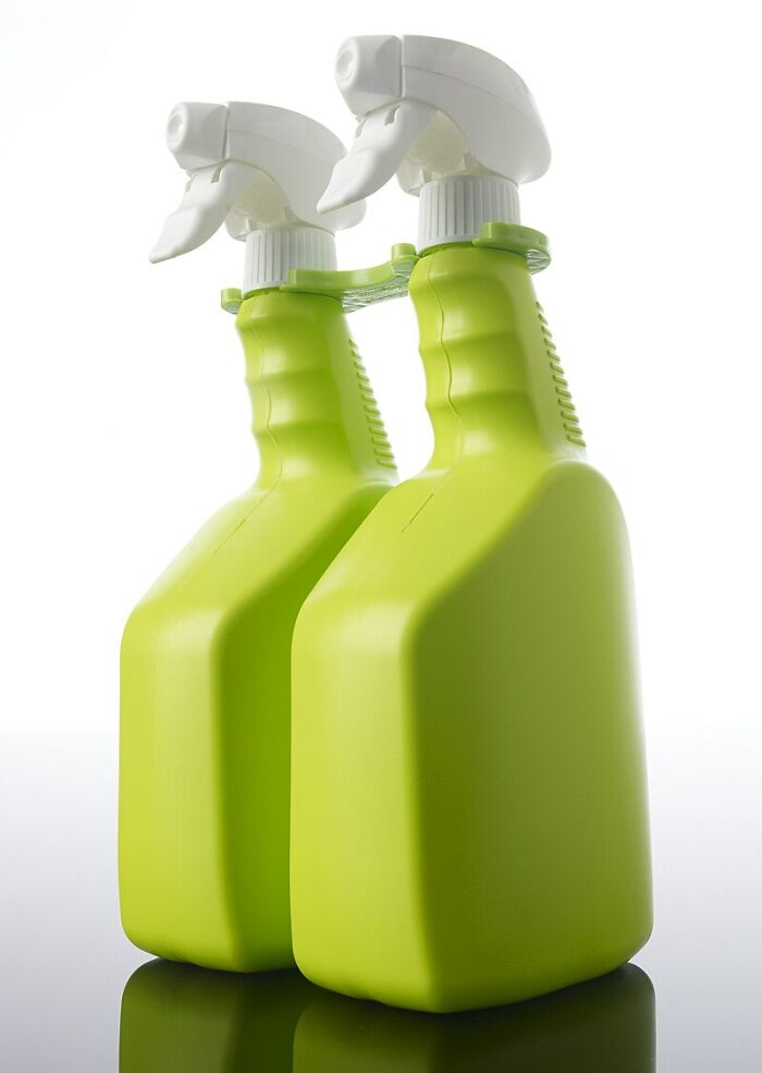 Dos botellas verdes de spray sobre fondo blanco, ilustrando posibles riesgos en retos fatales de TikTok.