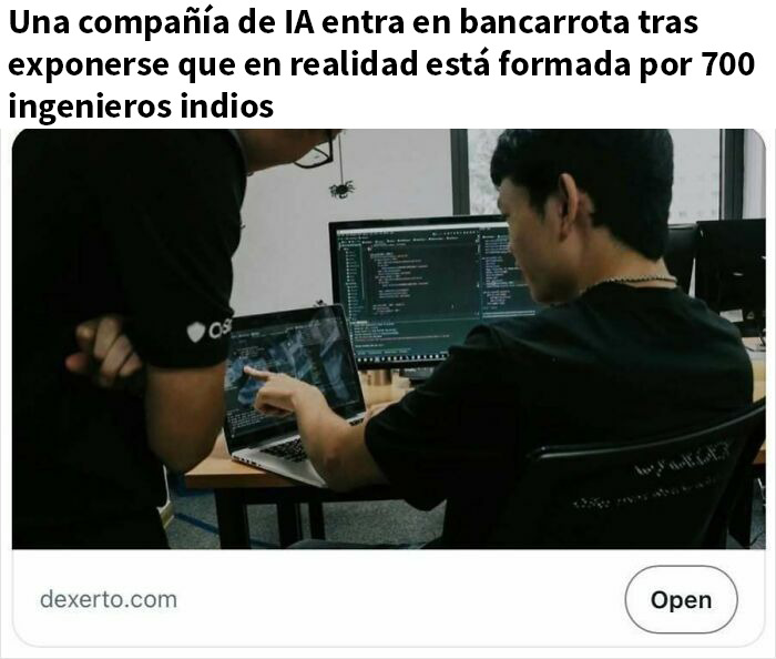 Dos personas revisan código en laptops en oficina, ilustrando titulares que parecen sátira pero son ciertos.