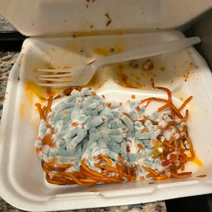 Imagen extraña y bizarra de arroz frito deconstruido con verduras dispuestas en líneas ordenadas en bandeja negra.