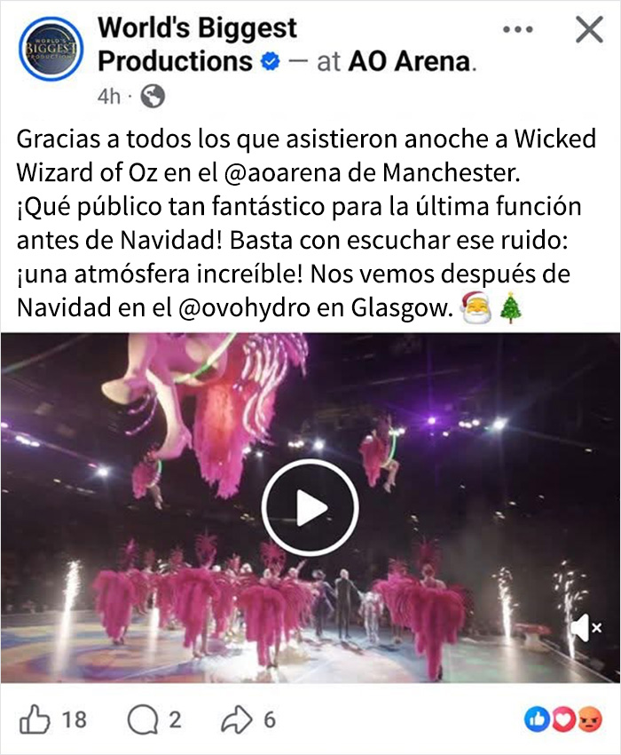 Espectáculo de El mago de Oz en teatro con bailarines en vestuarios rosas y luces sobre el escenario.