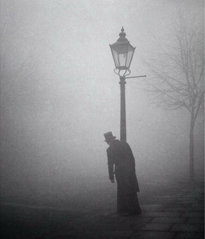 Un hombre borracho con sombrero de copa y cola se aferra a un poste de luz, Londres, 1934. Foto de Bill Brandt