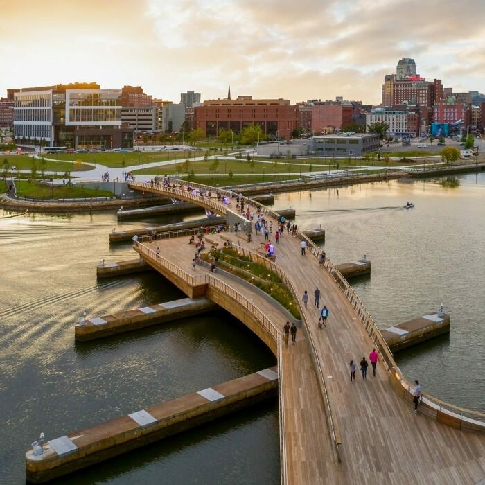 Puente peatonal curvo que une a dos partes frente al río de Providence, Rhode Island
