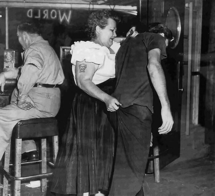 "Cairo Mary", portera de Shanghai Reds (5ª y Beacon en San Pedro, California) acompaña a un cliente a la puerta. 1953