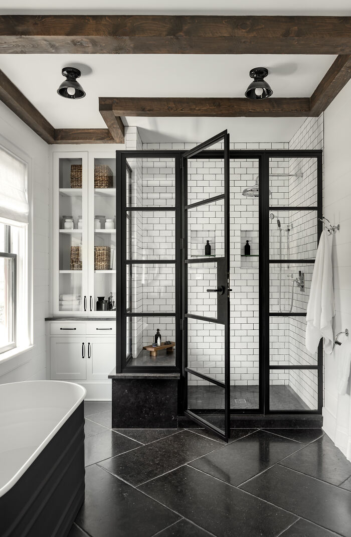 Ducha con azulejos blancos y puertas con marco negro en una casa de campo moderna, Hudson Valley, al norte del estado de Nueva York