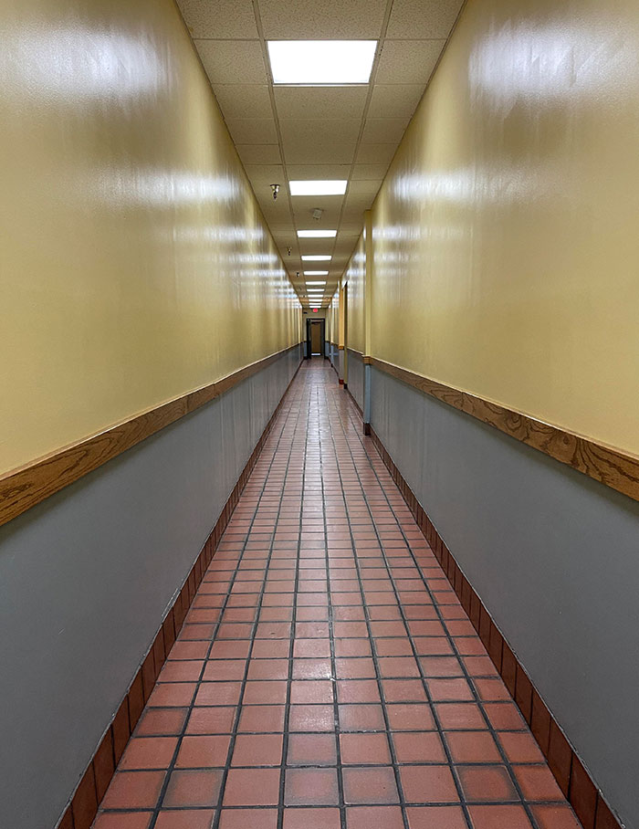 El pasillo que va al baño en el centro comercial. Tan pronto como entré, la música navideña que sonaba a través de los parlantes disminuyó y el sonido de las luces se elevó