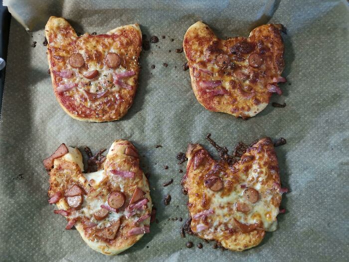 Hice lindas pizzas de gato para complacer a nuestro niño. Esto es después de que se hornea. Parecen víctimas de quemaduras