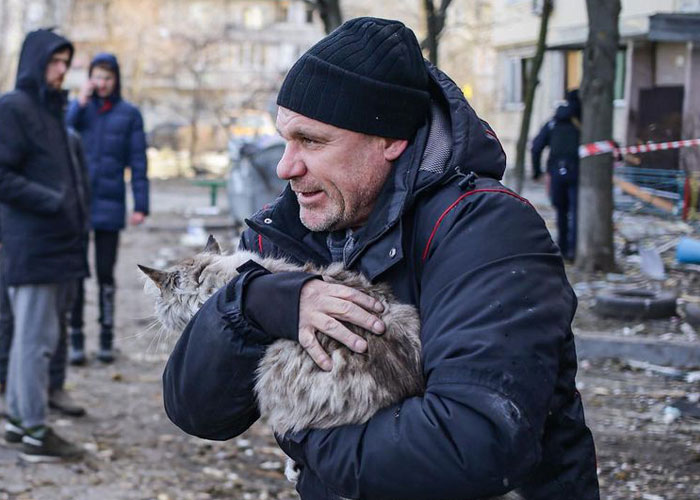 Esta mujer carga con su gato mientras lo consuela ante el sonido de las alarmas de ataque aéreo en Kyiv, Ucrania