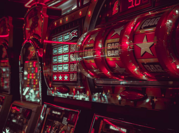 Máquinas tragamonedas rojas en casino con símbolos BAR y estrellas, representando datos muy informativos de juego.