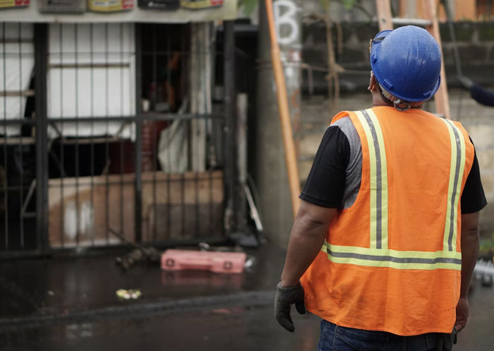 Obrero con chaleco naranja y casco azul observando una construcción para datos muy informativos curiosos y sorprendentes.