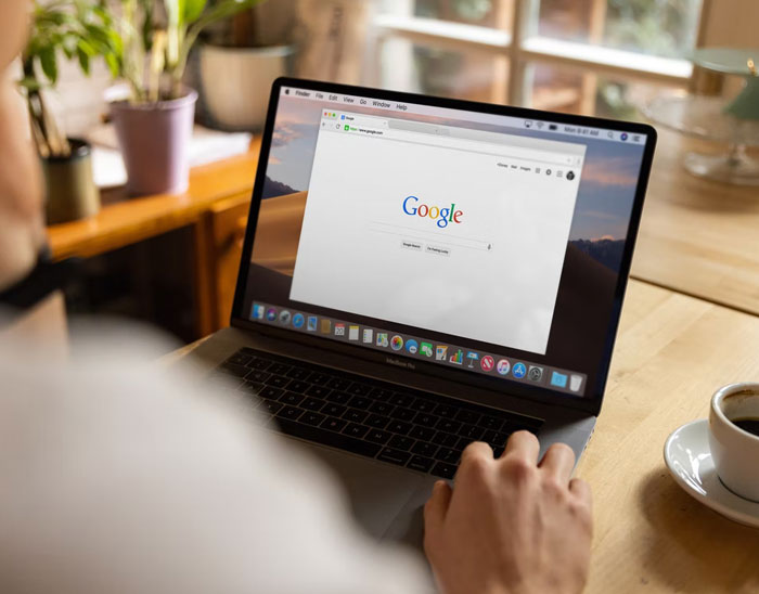 Persona usando laptop con página de Google abierta, buscando datos muy informativos para aprender nuevas respuestas.