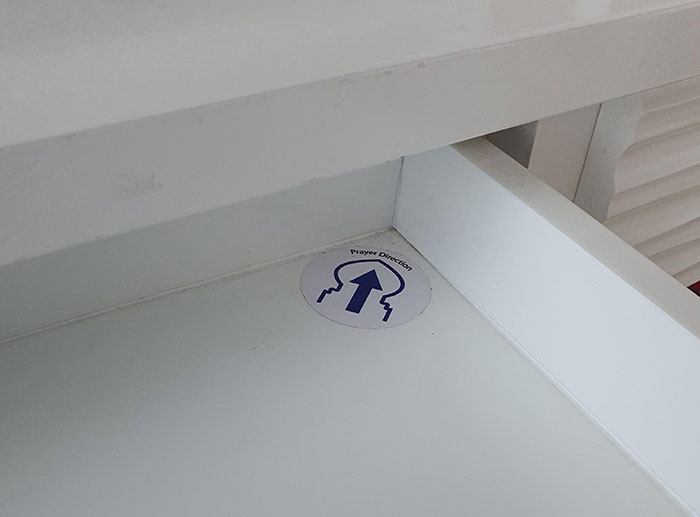 El cajón de esta habitación tiene una pegatina que señala la dirección para rezar hacia la Meca