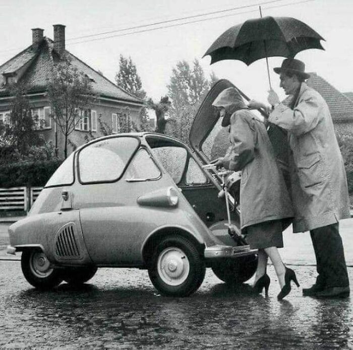 Una pareja entra en su Bmw Isetta, por la puerta principal, 1950