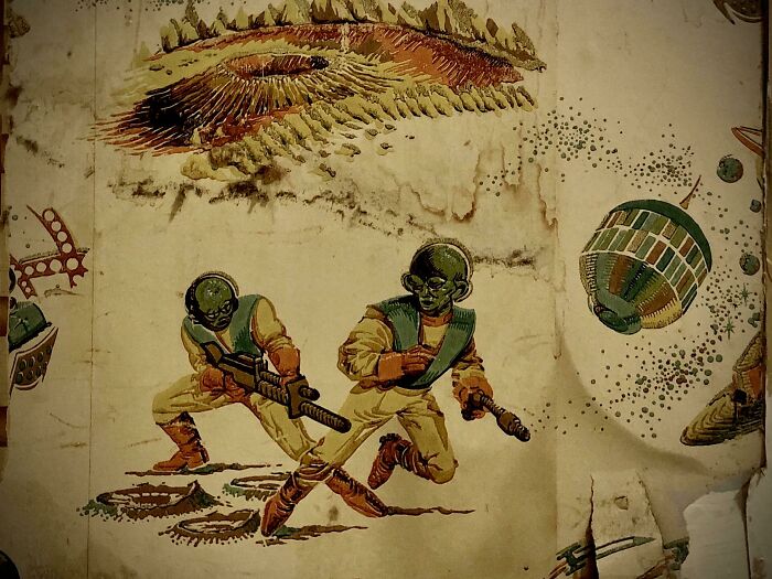 Quité un radiador de la pared para poder pintar y encontré un antiguo papel tapiz de una invasión extraterrestre