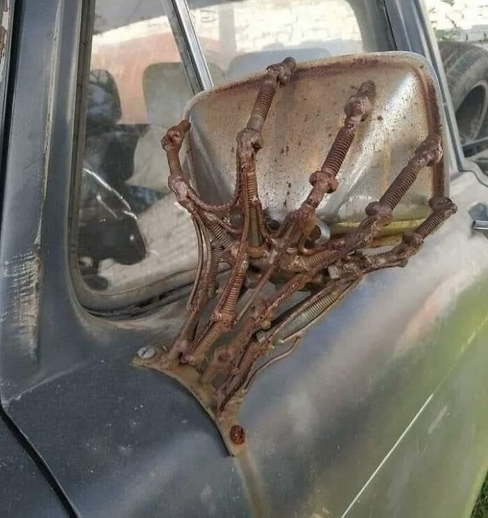 Un espejo retrovisor sostenido por una mano