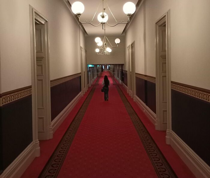 El pasillo del hotel la hace parecer diminuta