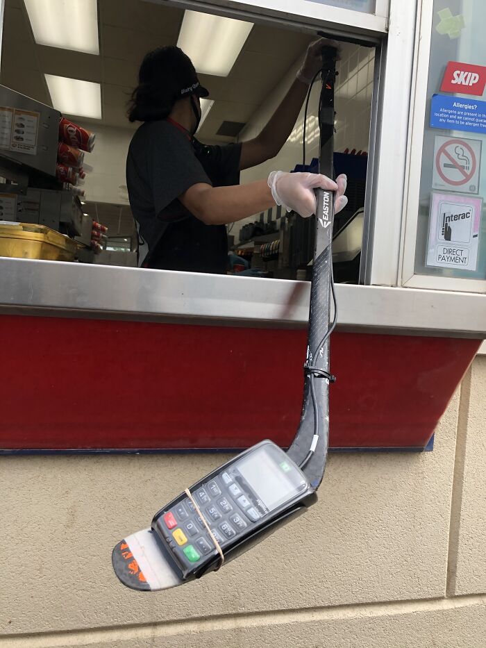 Este es un Dairy Queen Drive-Through en Canadá donde se mantiene la distancia social utilizando la máquina de cobros de tarjetas atada a un palo de hockey. No se puede imaginar esto