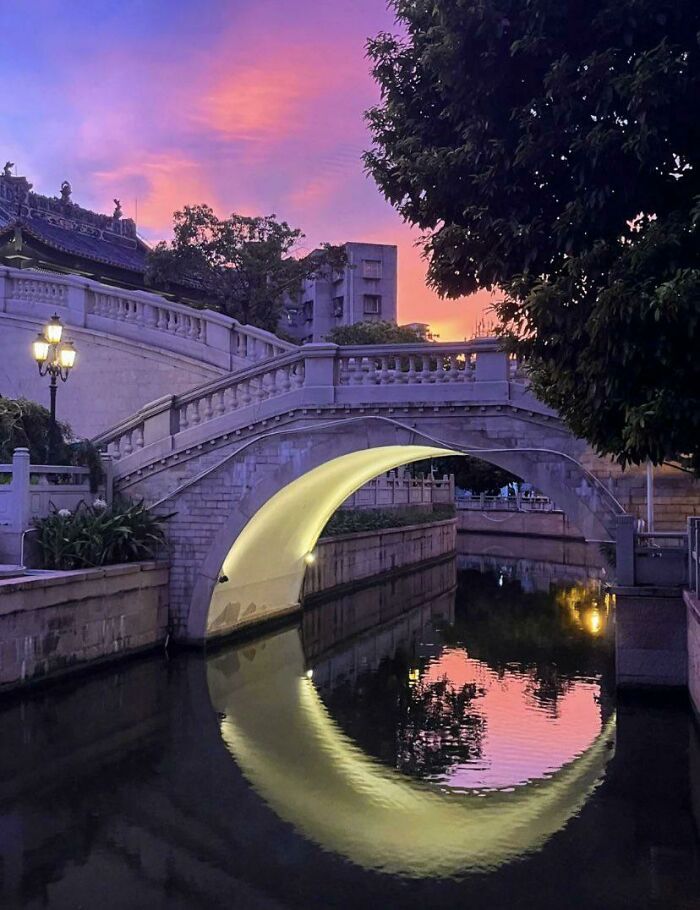 La iluminación bajo este puente hace que parezca que hay una luna creciente en el agua