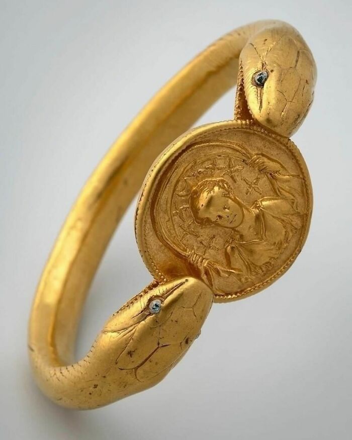 Brazalete encontrado en una casa de Pompeya: serpiente de dos cabezas y ojos de cristal, sosteniendo un medallón con la imagen de la diosa Diana