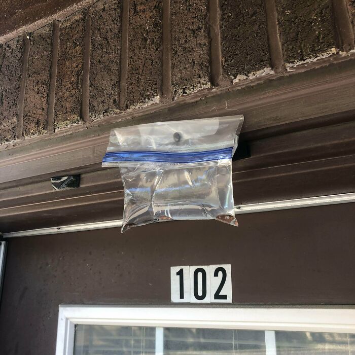 La vi mientras caminaba por la calle, es una bolsa Ziplock atada arriba de una puerta. Parece que tiene agua y algunas monedas. ¿Para qué será?
