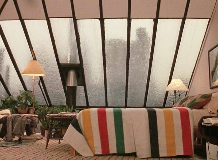 ¿A quién le gustaría acurrucarse en la cama de este apartamento, para mirar y escuchar caer la lluvia en esas ventanas inclinadas? Decoración de un ático en la película Alice de Woody Allen