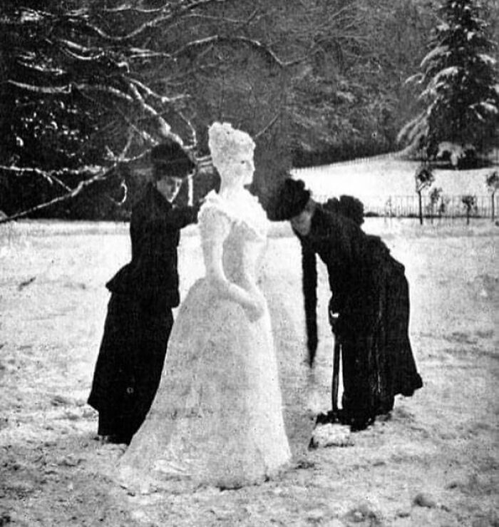 Dos mujeres haciendo una mujer de nieve. Esta foto fue originalmente impresa en la revista Strand, volumen III, en 1892
