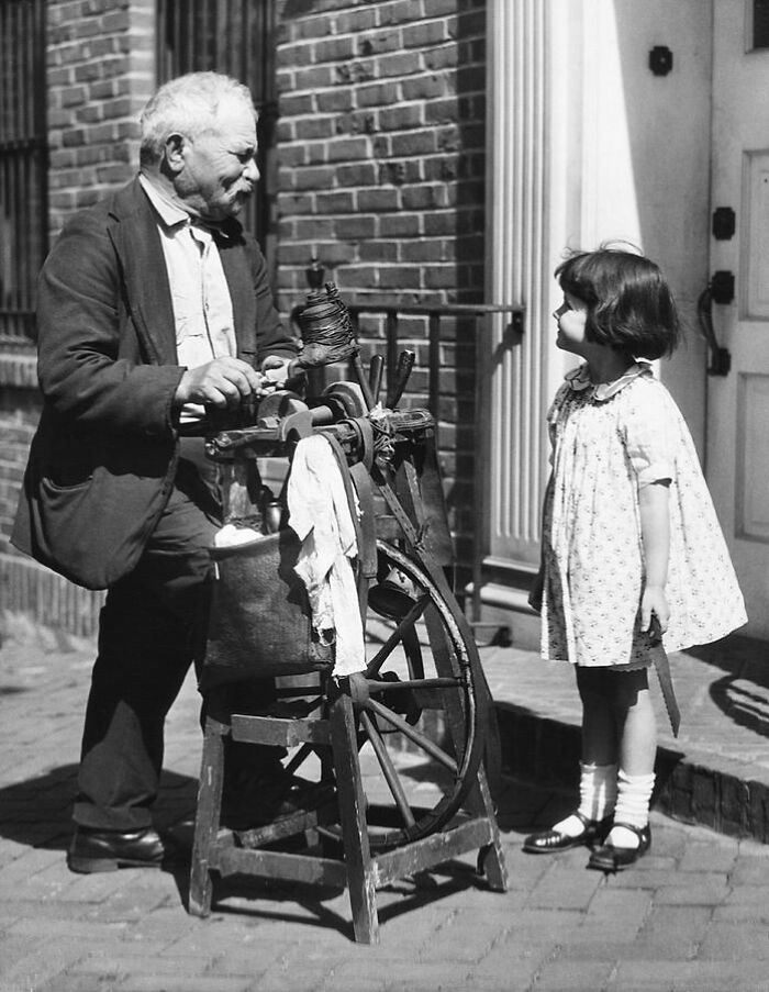 Afilador de cuchillos ambulante con un cliente. Estados Unidos, principios de 1910