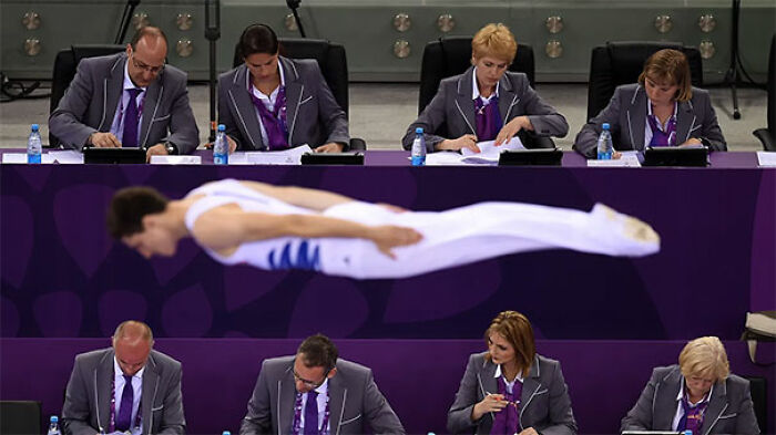Dos filas de jueces ignorando a un gimnasta 