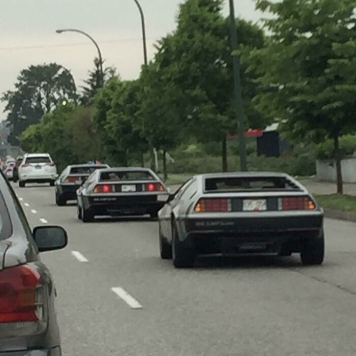 Tres Deloreans conduciendo en fila