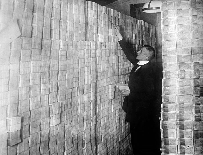 Un banquero berlinés cuenta fajos de marcos apilados en 1923