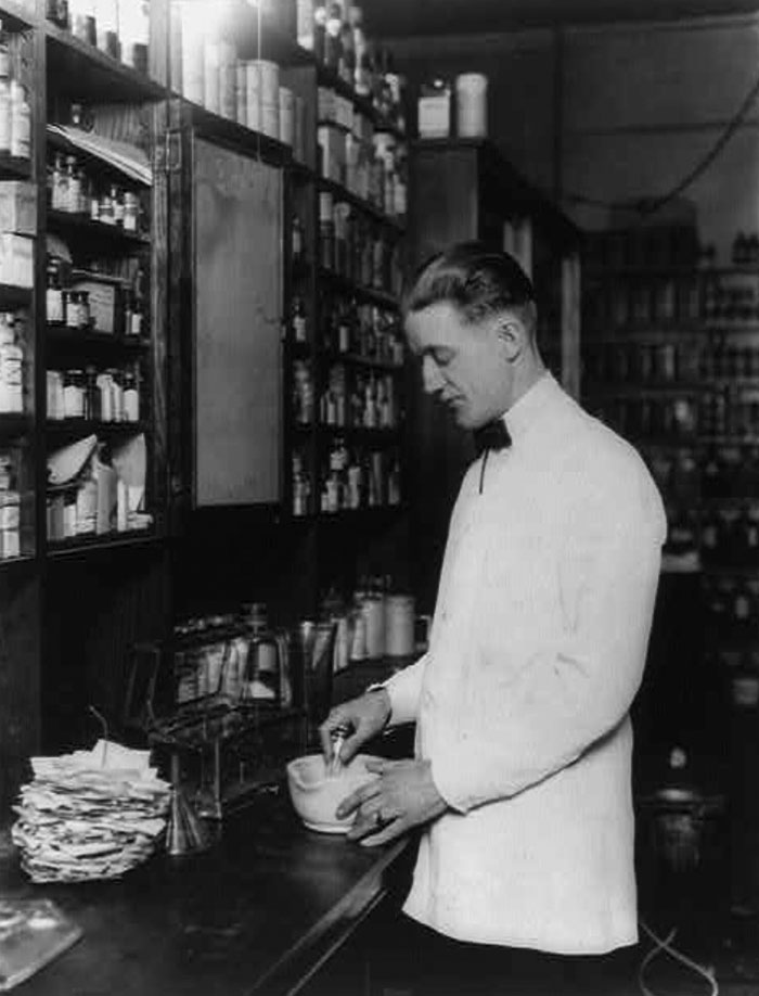 Farmacéutico mezclando medicamentos con un mortero. 5 de marzo de 1923