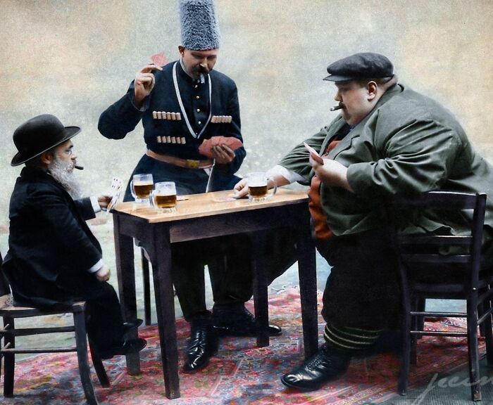 Un hombre más bajo, el más alto y el más gordo juegan a las cartas