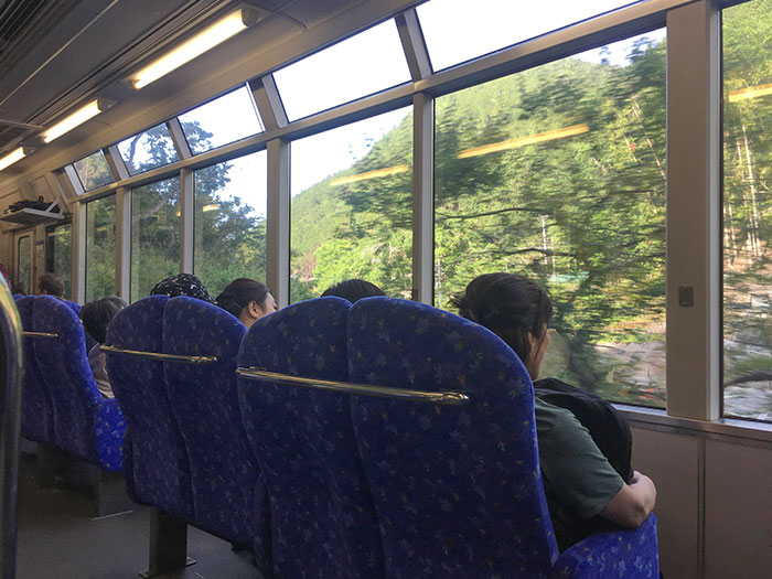 Asientos de tren que dan hacia afuera para que puedas ver el paisaje, en Japón