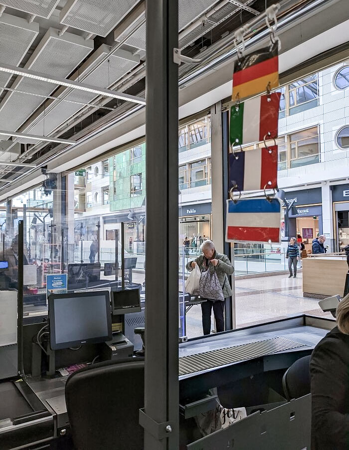 En esta tienda, las cajeras cuelgan banderas para indicar qué idiomas hablan
