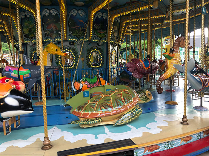 Carrusel en Hong Kong con una tortuga montada en el suelo para niños en silla de ruedas