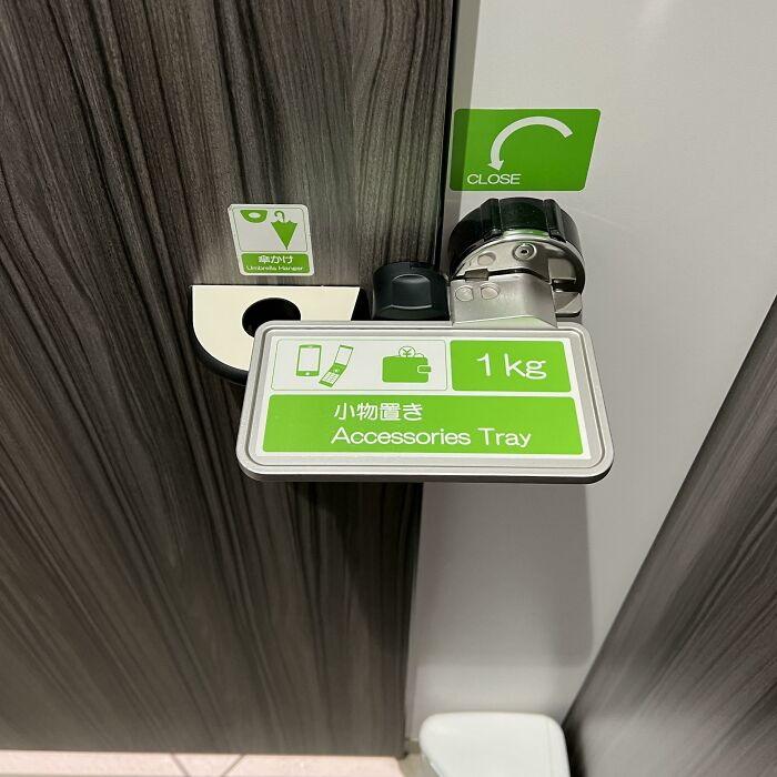 Cerrojo de la puerta de un retrete público que sirve para sostener cosas a la vez. Japón