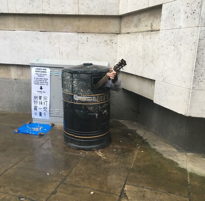 Hay un tipo tocando temas de Johnny Cash dentro de una papelera en Cambridge