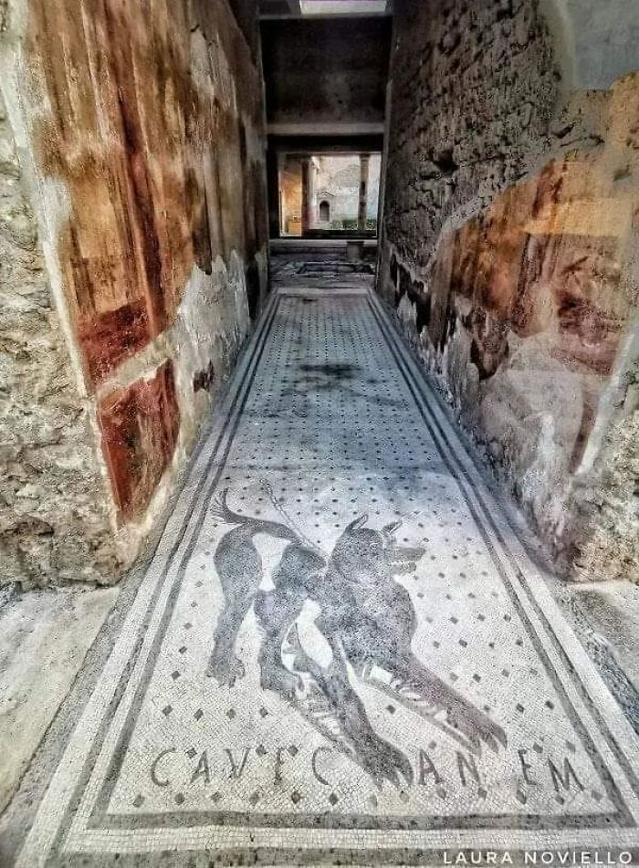 Mosaico romano a la entrada de la casa del poeta trágico en las ruinas de Pompeya, destruida en el año 79 d.C.