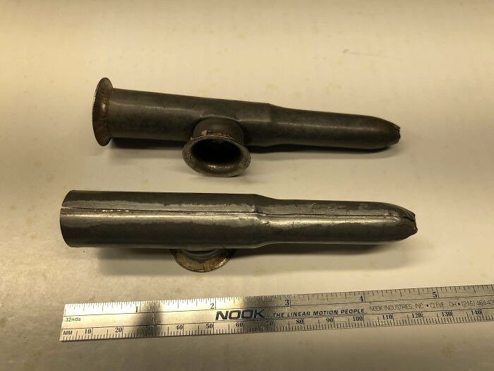 Dos pequeños objetos metálicos con tela dentro del agujero lateral.