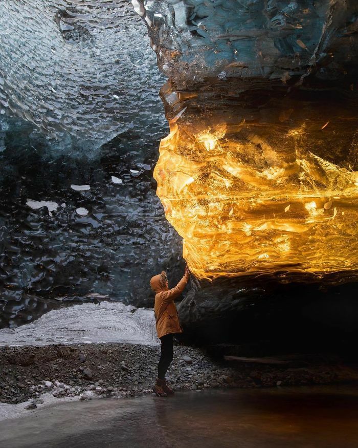 Los rayos del atardecer entran en esta cueva de hielo en el ángulo justo, y ahora parece de ámbar