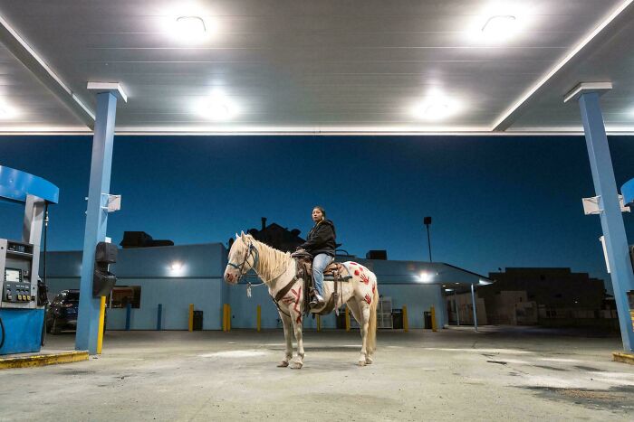 Joven a caballo en una gasolinera
