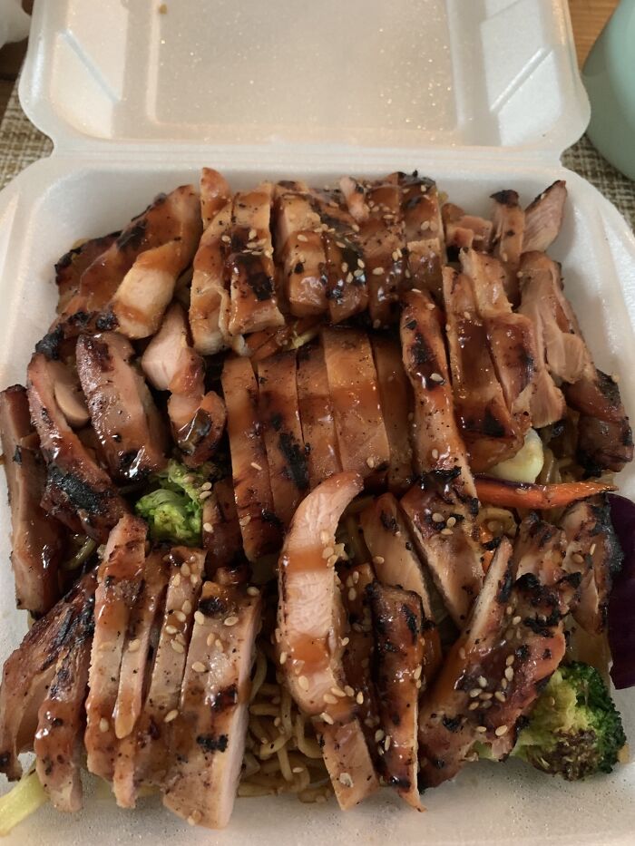 Pollo a la parrilla con salsa teriyaki y semillas de sésamo en caja para llevar, personas felices recibiendo exactamente su pedido.
