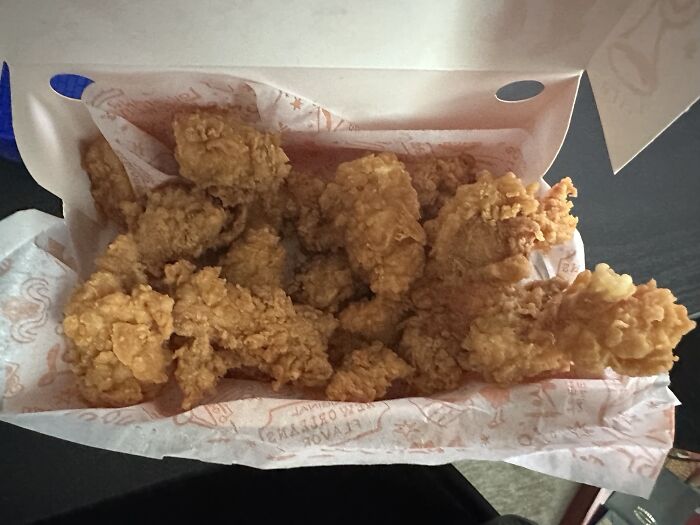 Caja con alitas de pollo frito crocantes mostrando alegría por recibir exactamente lo que pidieron.